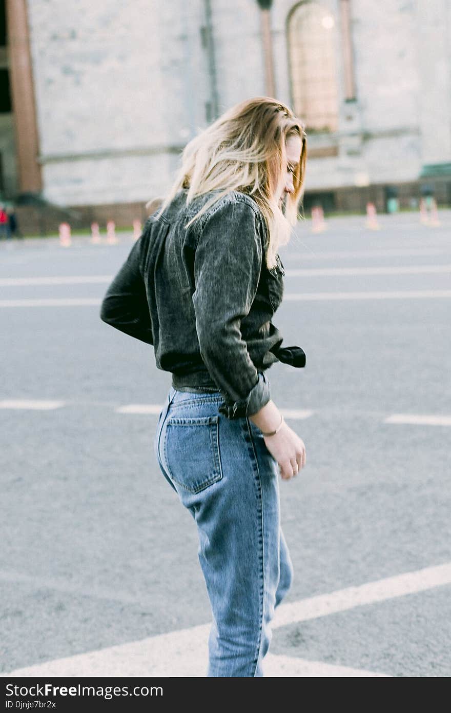 Photo of Woman Wearing Black Denim Jacket and Blue Jeans