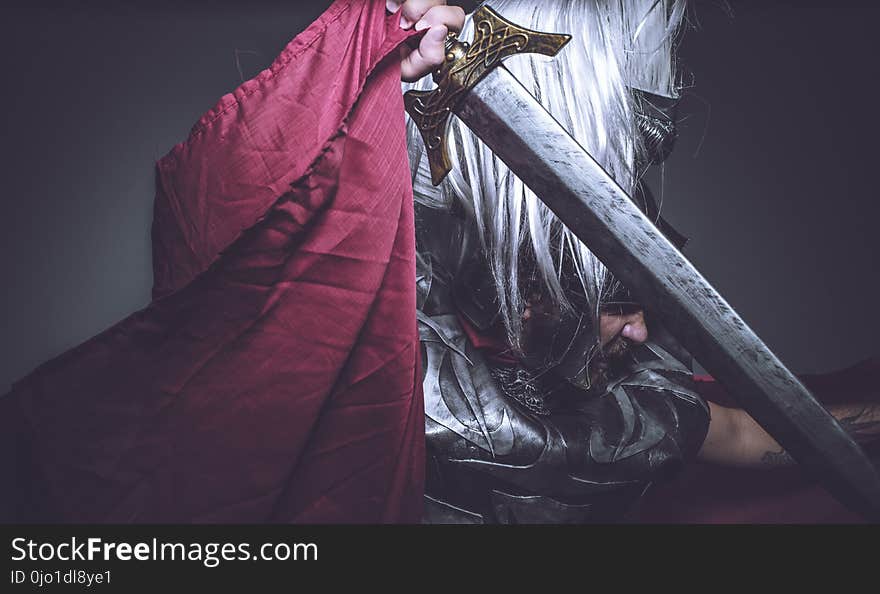 Roman gladiator, wrestler and warrior of Rome with helmet and red cloak, carries an iron sword, beard and long hair.