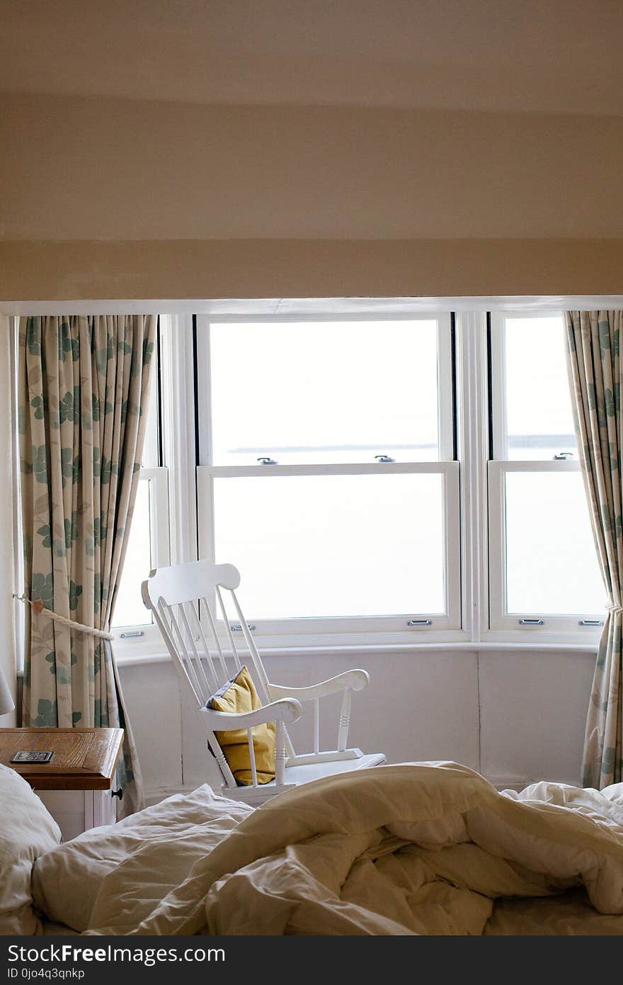 Photo of Empty White Rocking Chair Beside Window