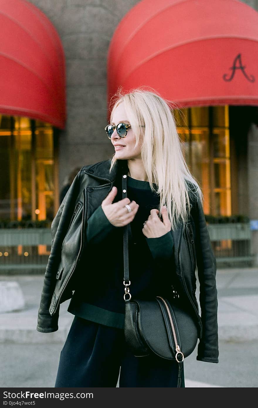 Woman Wearing Black Leather Jacket Near Brown and Red Building