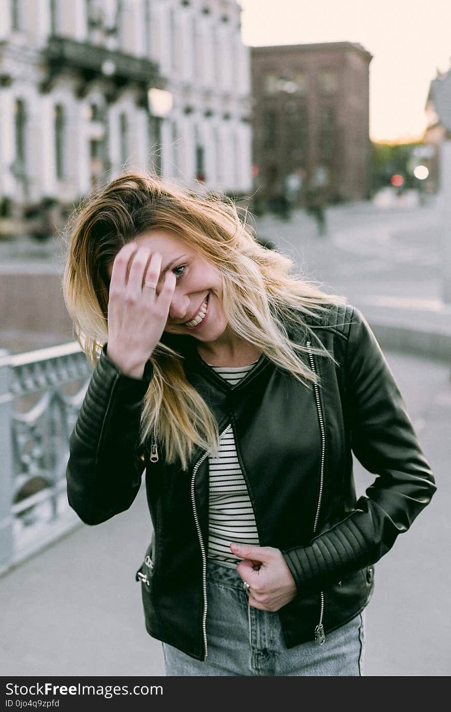 Photo of Woman Wearing Black Zip-up Leather Jacket and White and Black Striped Shirt