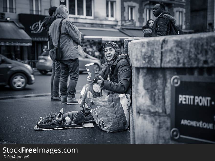 Person Sitting Behind Wall Grayscale Photo