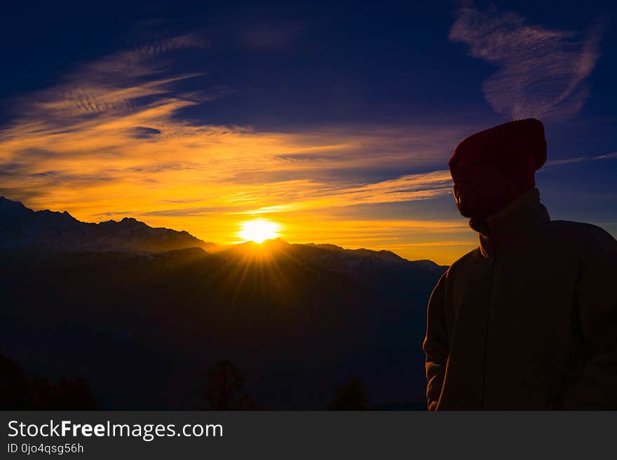 Silhouette of Person Near Mountain during Golden Hour