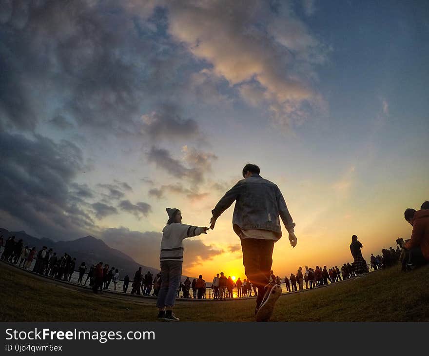 Black Haired Man Wearing Blue Denim Jacket and Orange Pants during Sunset