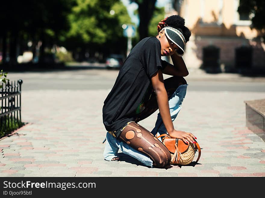 Woman Wearing Black T-shirt Kneeling on Ground