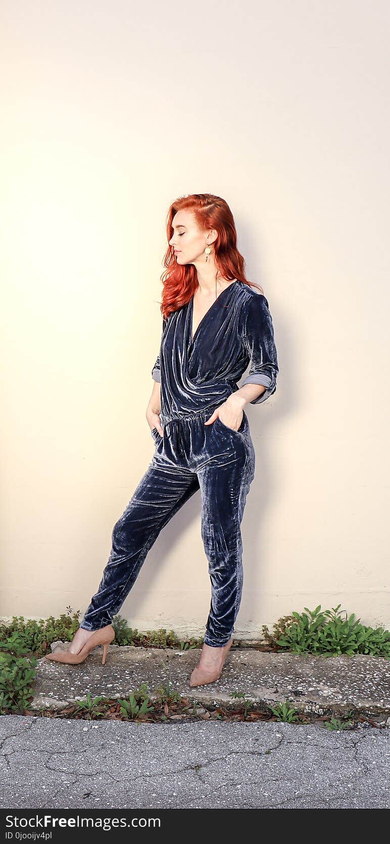 Woman Wearing Black Velvet Surplice Jumpsuit Standing Beside Wall