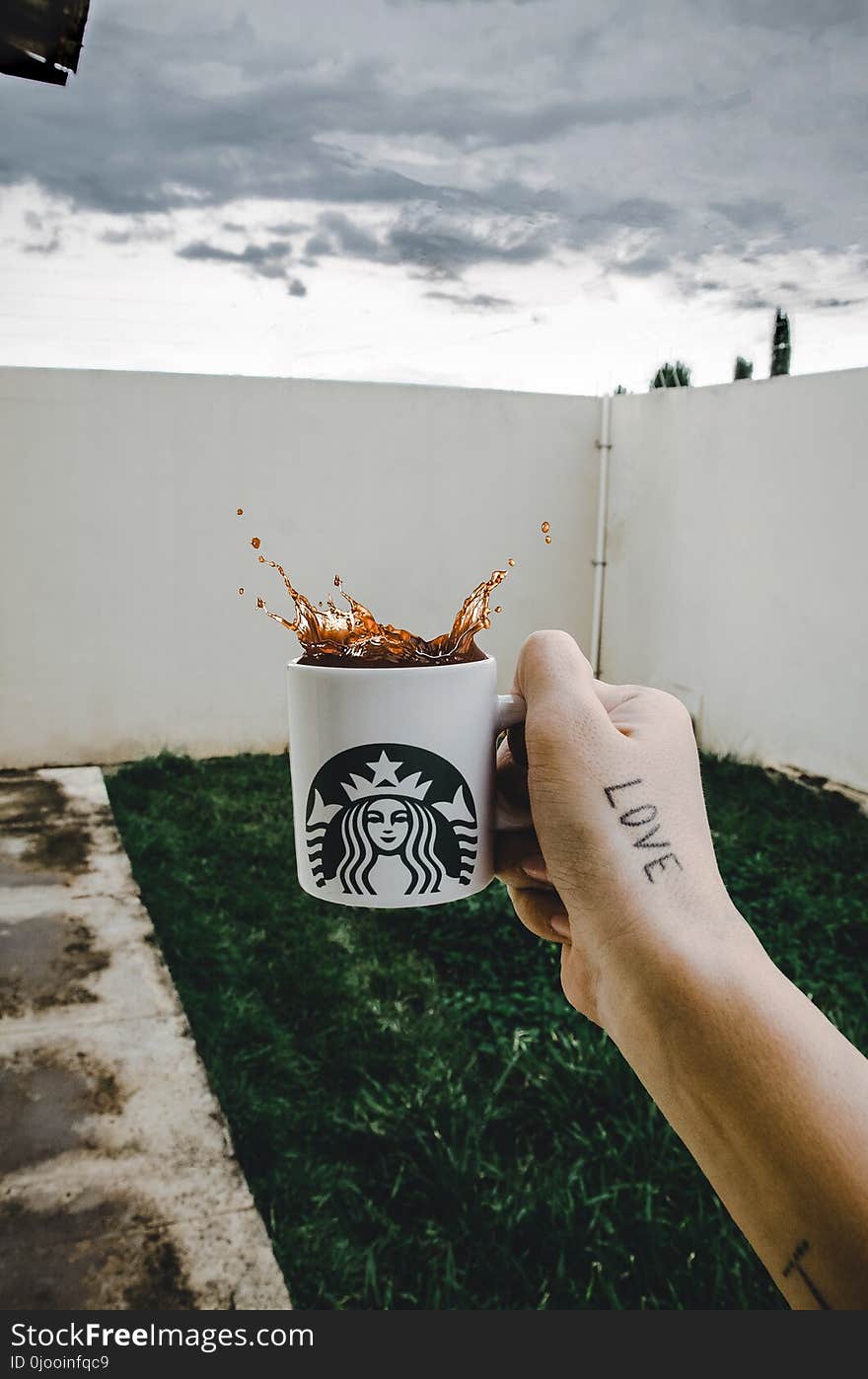 Person Holding Starbucks Cup With Brown Beverage