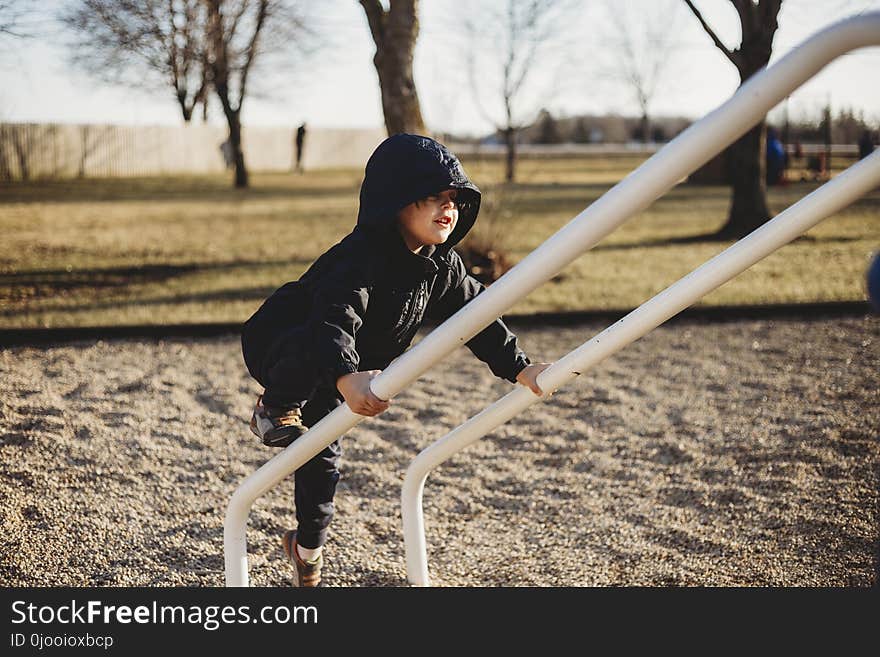 Girl in Black Hoodie and Pants Holding on White Metal Handrail at Daytime