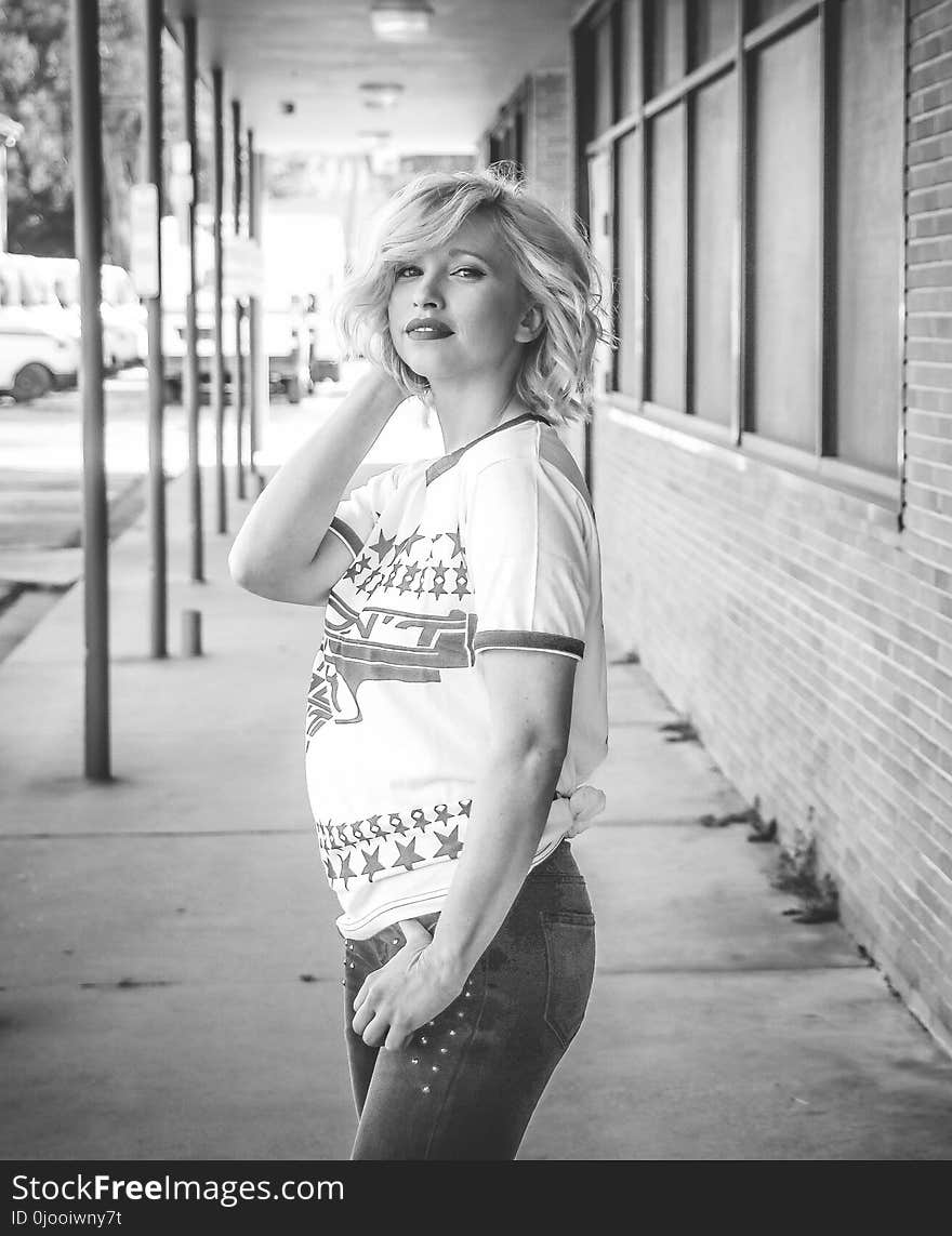 Woman Holding Hair and Jeans Pocket Grayscale Photo