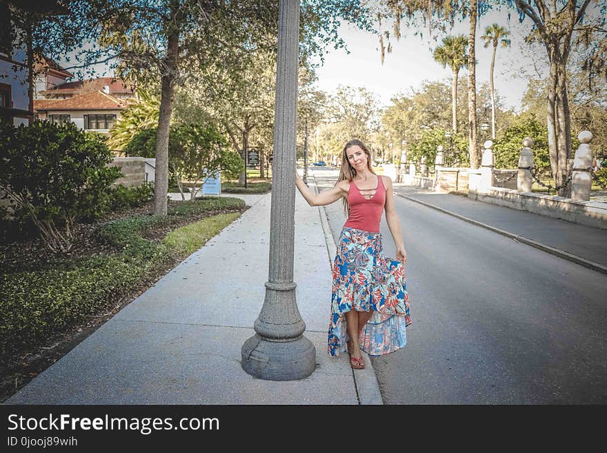 Woman Wearing Red and Blue Floral Tank Dress Beside Concrete Road