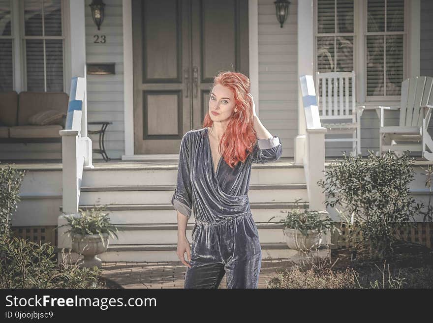 Woman Wearing Gray Peplum Elbow-sleeved Jumpsuit Standing in Front of House