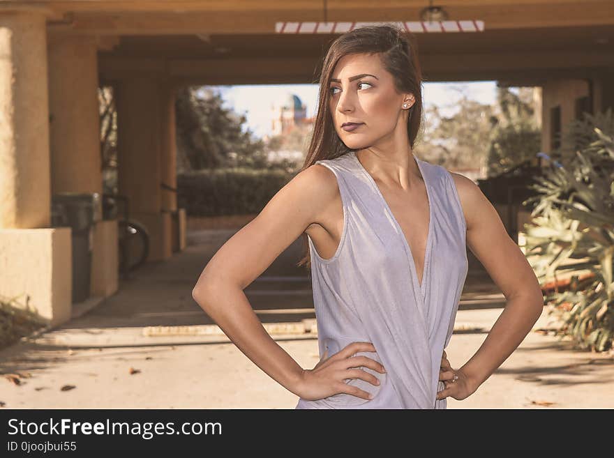 Woman in Gray Sleeveless Top Standing in Front White Bridge