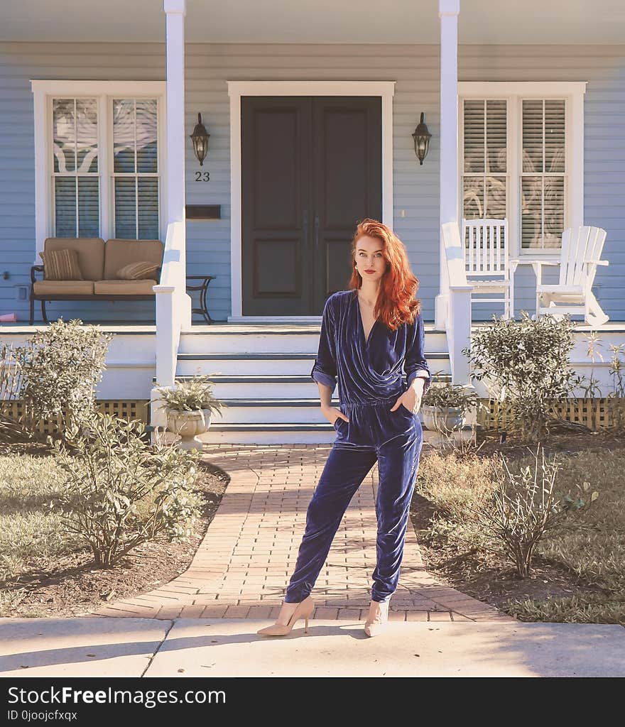 Woman Wearing Black Jumpsuit Standing Near the House