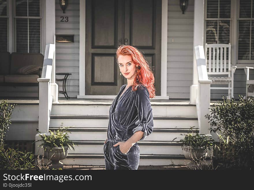 Woman in Gray Jumpsuit Standing in Front of House