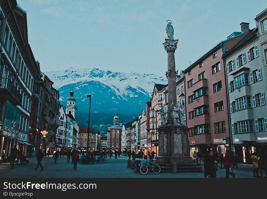 Brown and White Concrete Buildings Near Snow Coated Mountain