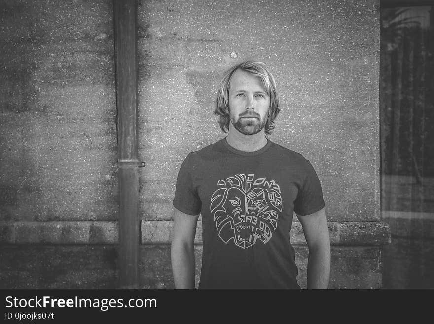 Man in T-shirt Standing in Front of Building