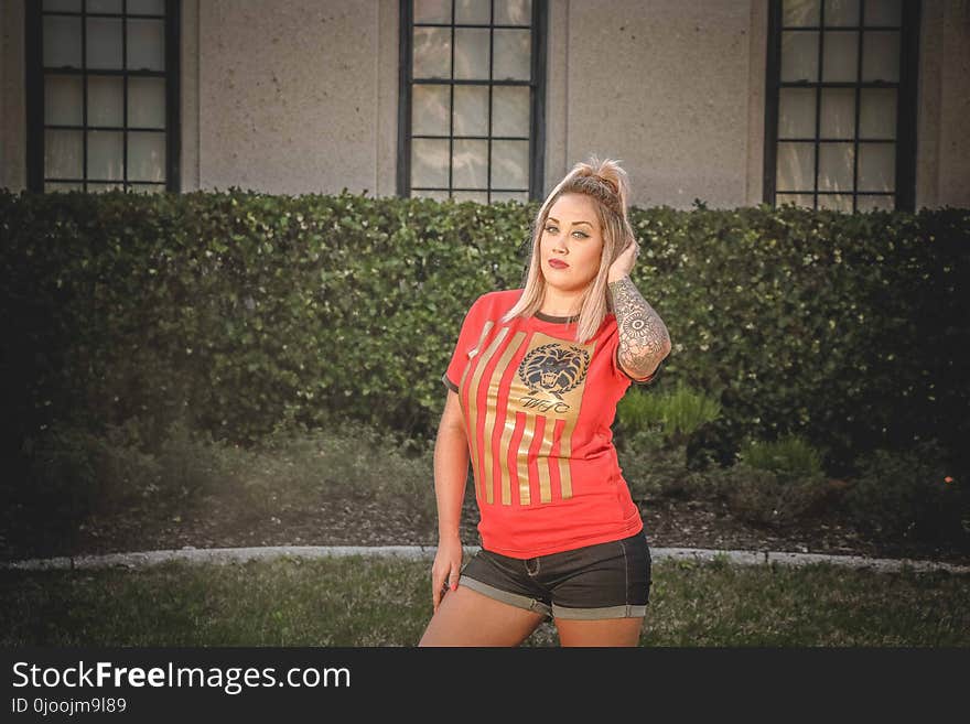 Woman Wearing Brown and Red T-shirt Standing Near the House