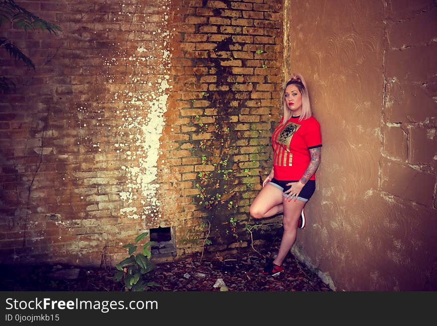 Woman Wearing Red Crew-neck Sleeved Shirt and Blue Denim Short Shorts