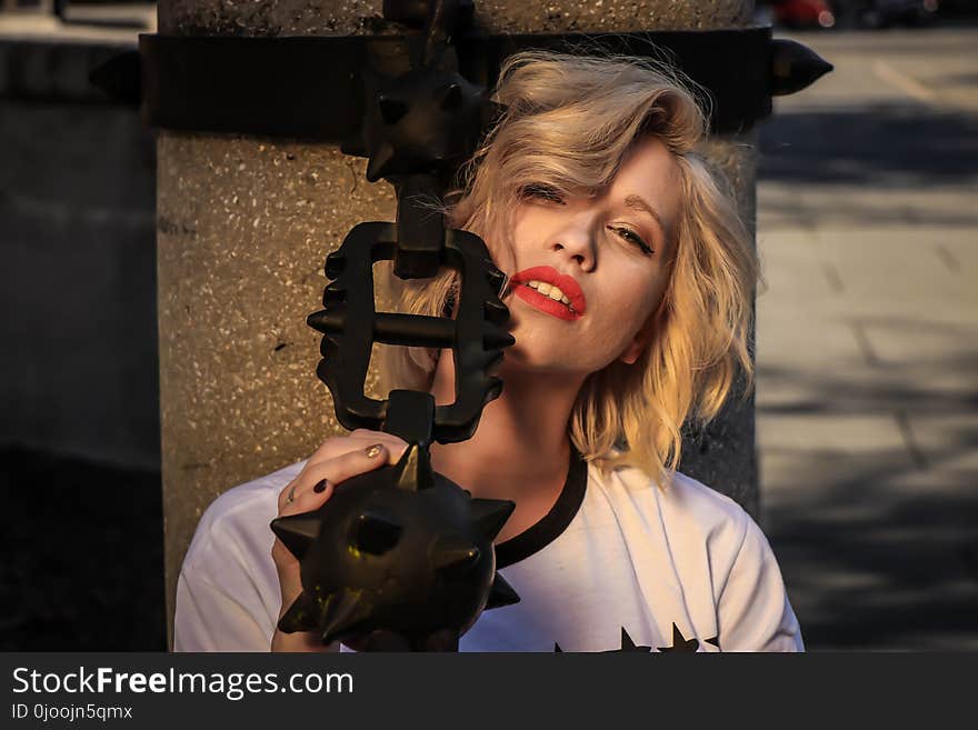 Woman Wearing White Crew-neck Shirt Holding Black Weapon