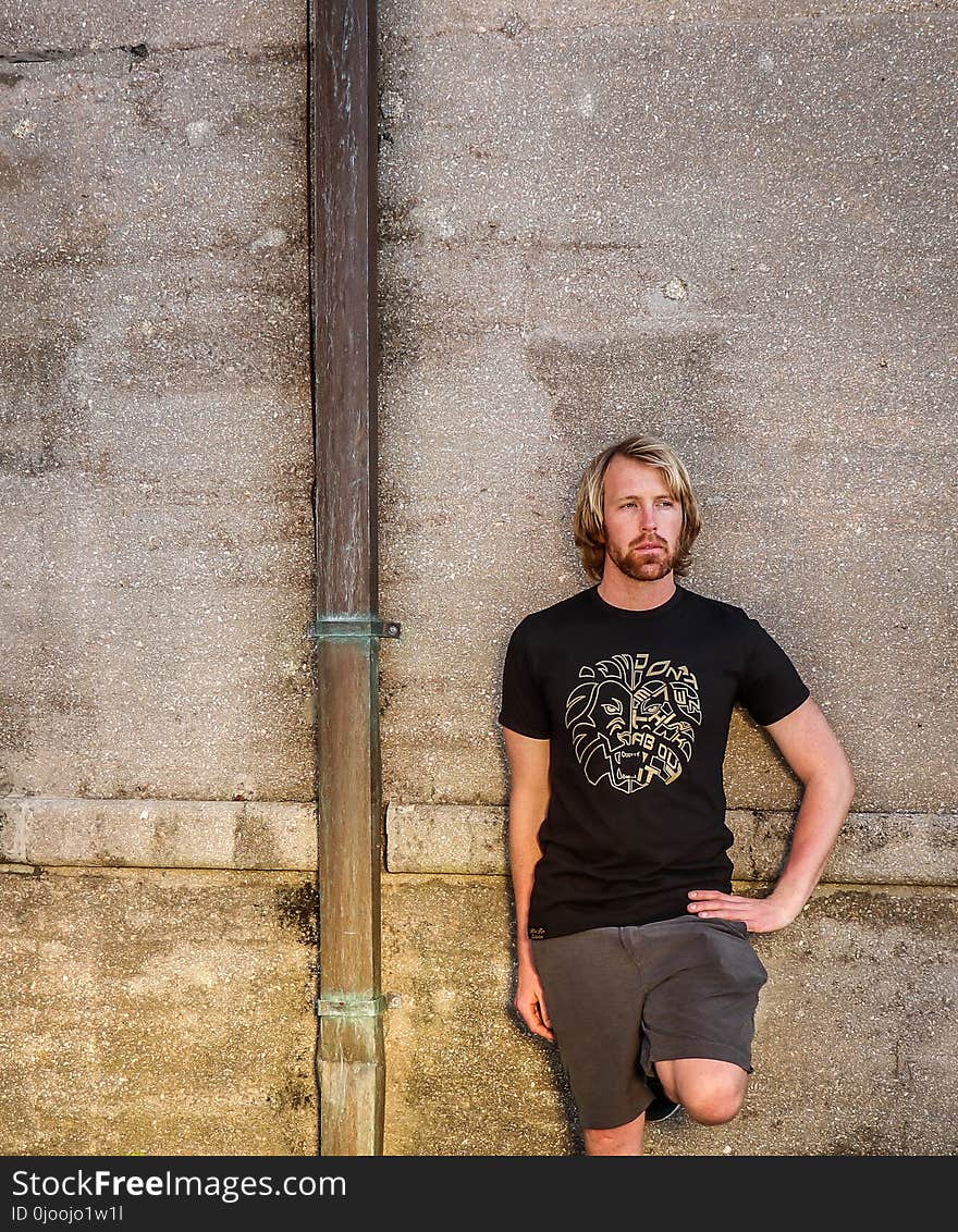 Man in Black Shirt and Bermuda Shorts