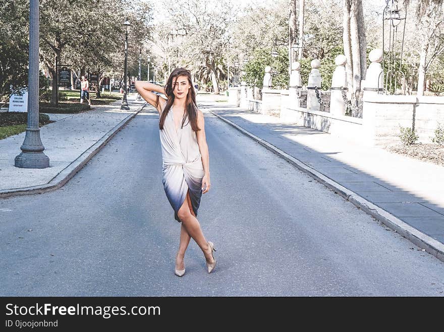 Woman Standing on Street With Cross Leg