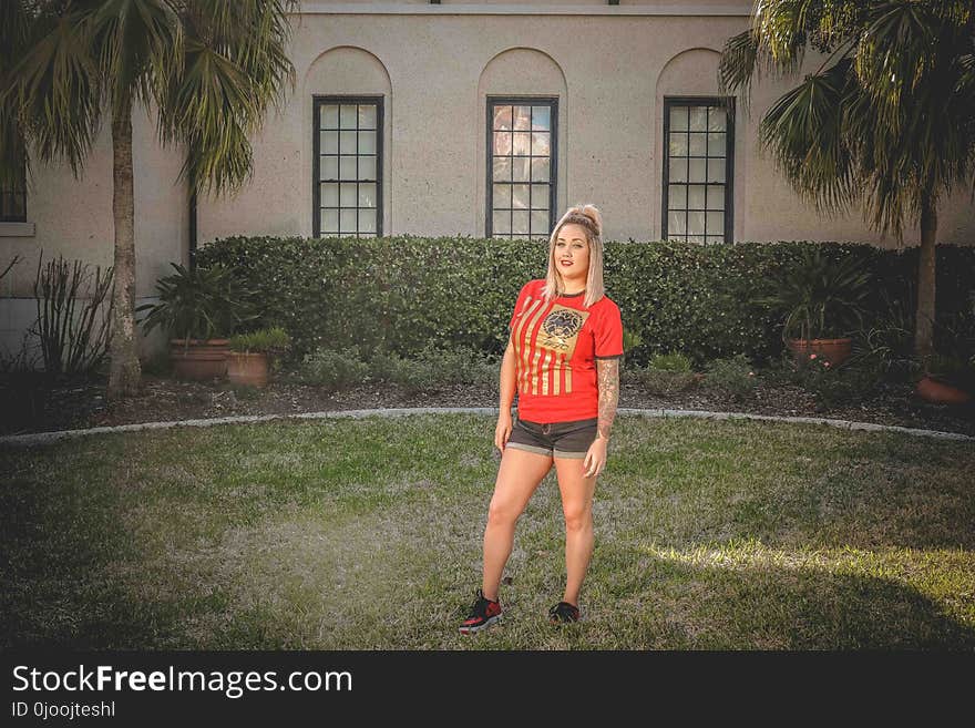 Woman Standing on Grass Field in Front of House