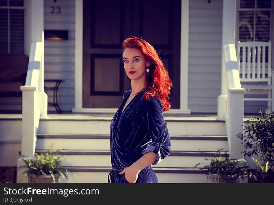 Woman Standing in Front of White Wooden House