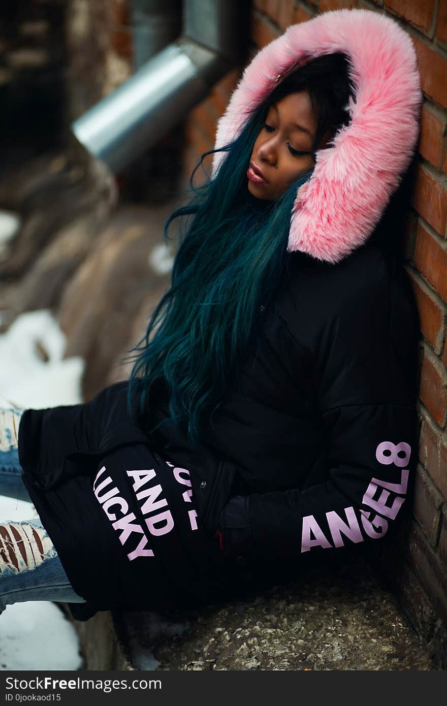 Woman Wearing Black and Pink Coat Leaning on Wall