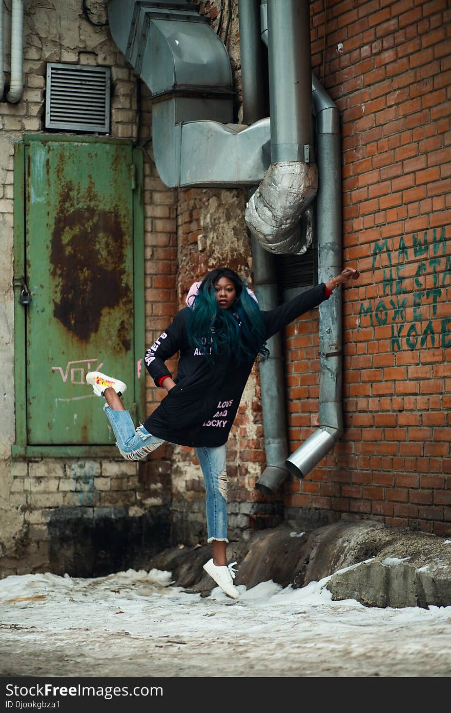 Woman Wearing Black Jacket Near Red Concrete Bricks