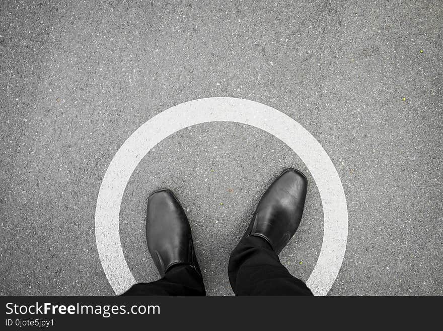 Businessman standing in white circle line feeling it is a limit and safety and never think different. Businessman standing in white circle line feeling it is a limit and safety and never think different.