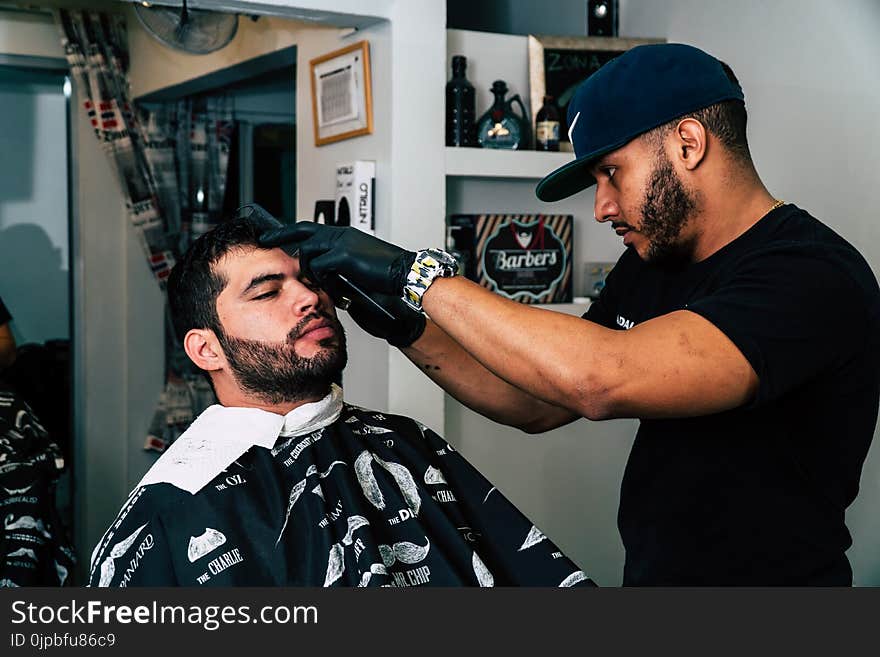 Man Wearing Black Shirt Trimming the Hair of Man