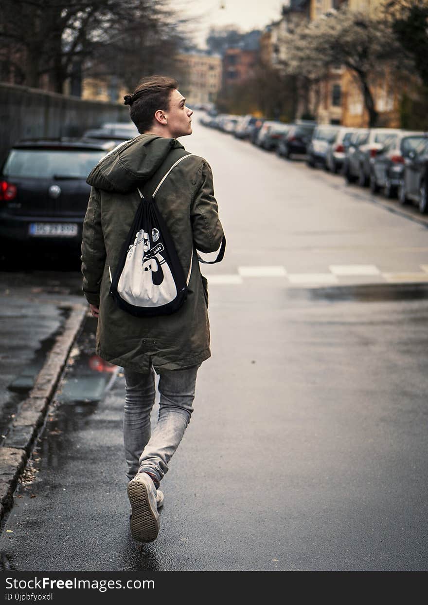 Person Wearing Blue Jeans With Black and White Drawstring Bag