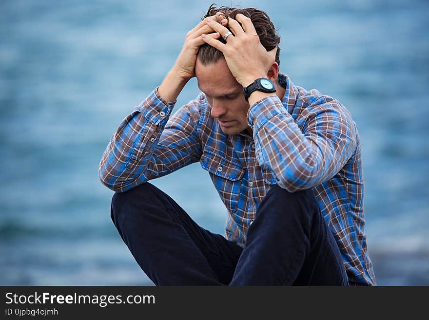 Man in Blue and Brown Plaid Dress Shirt Touching His Hair