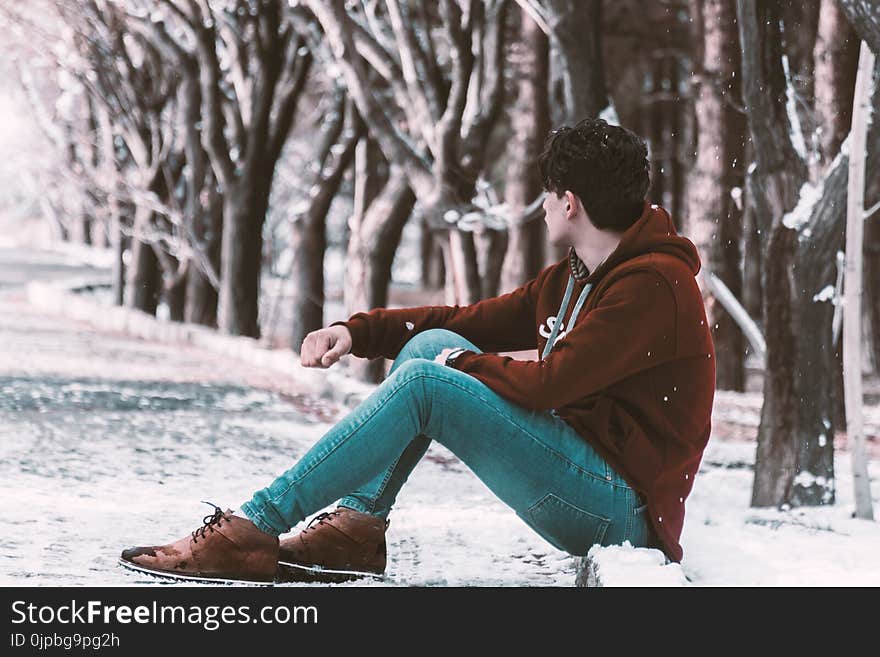 Man Sitting on Ground With Snow