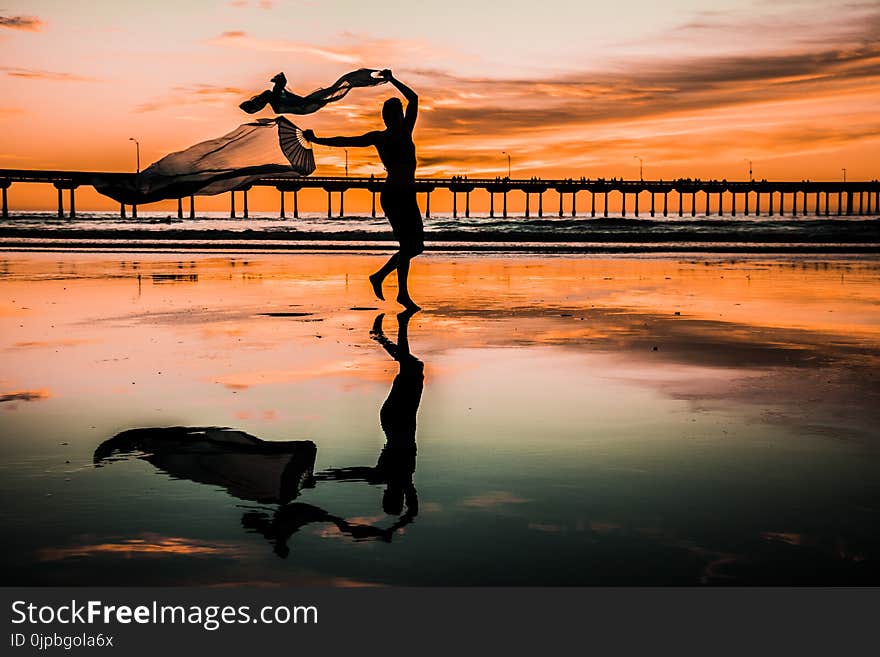 Silhouette Photo of Person Holding Scarf