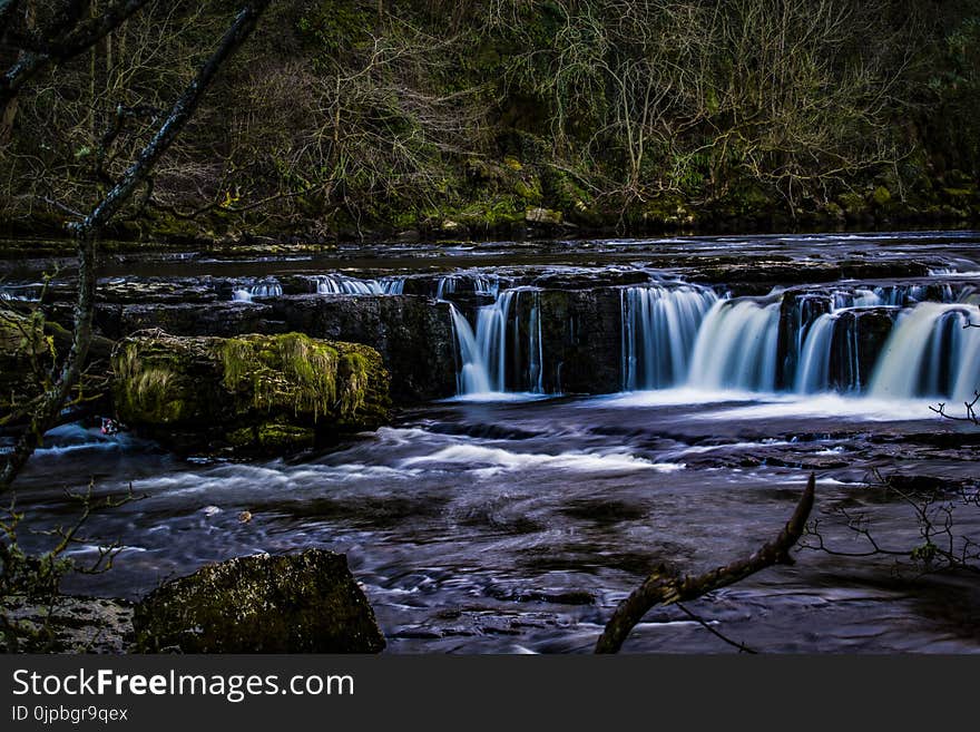 Selective Photo of Body of Water Surrounded by Trees and Big Rocks