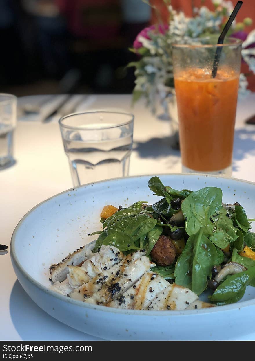 Selective Focus Photography of Cooked Food With Vegetables in Plate Near Glass of Water