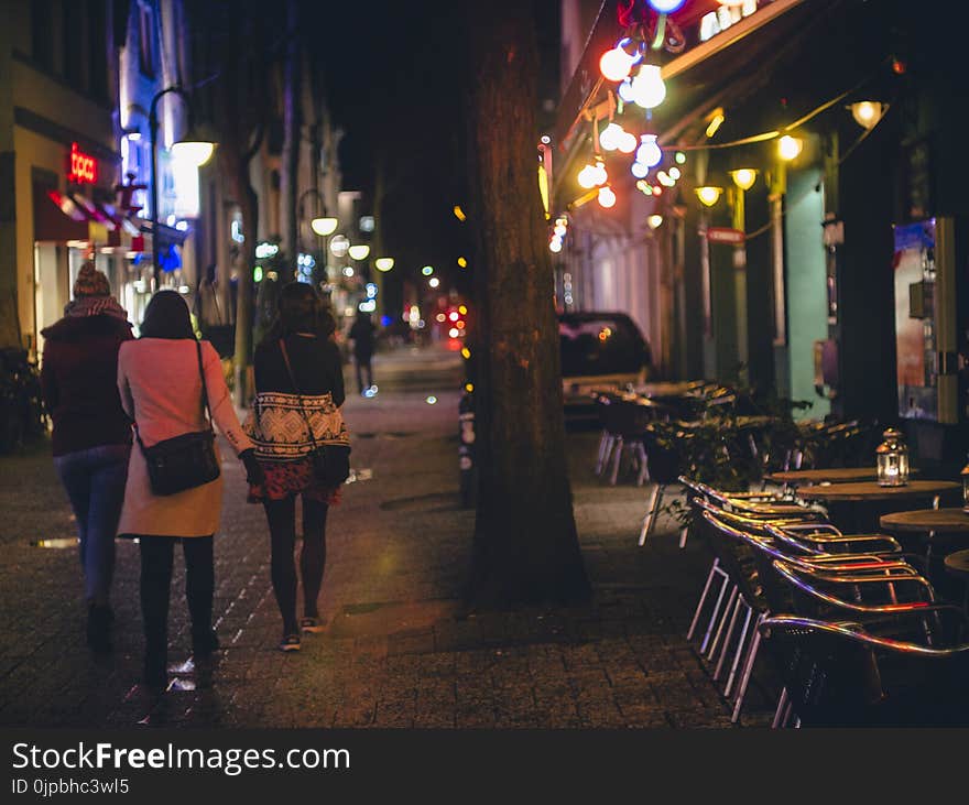 Three Women Walking during Nightime