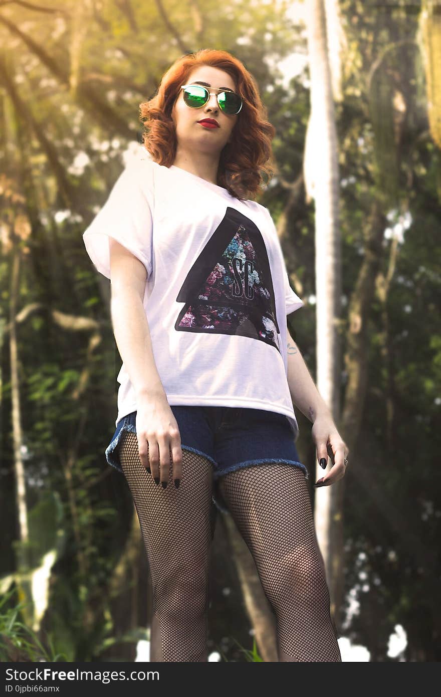 Low Angle Photo of Woman Near Tall Trees during Crepuscular Rays