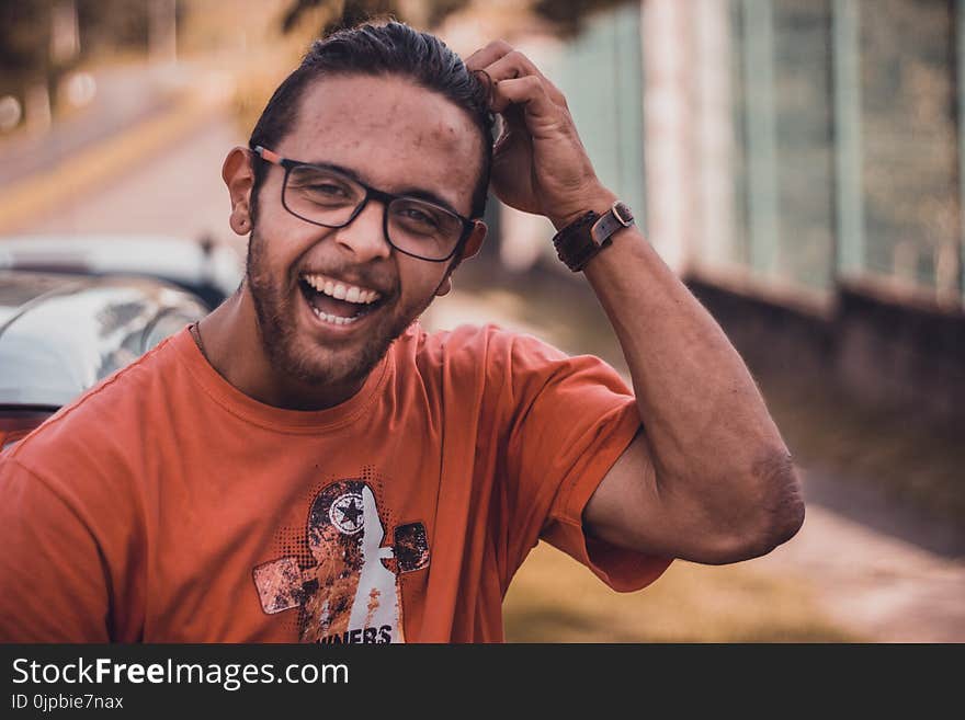 Selective Focus Photography of Man Smiling Putting Hands on Head