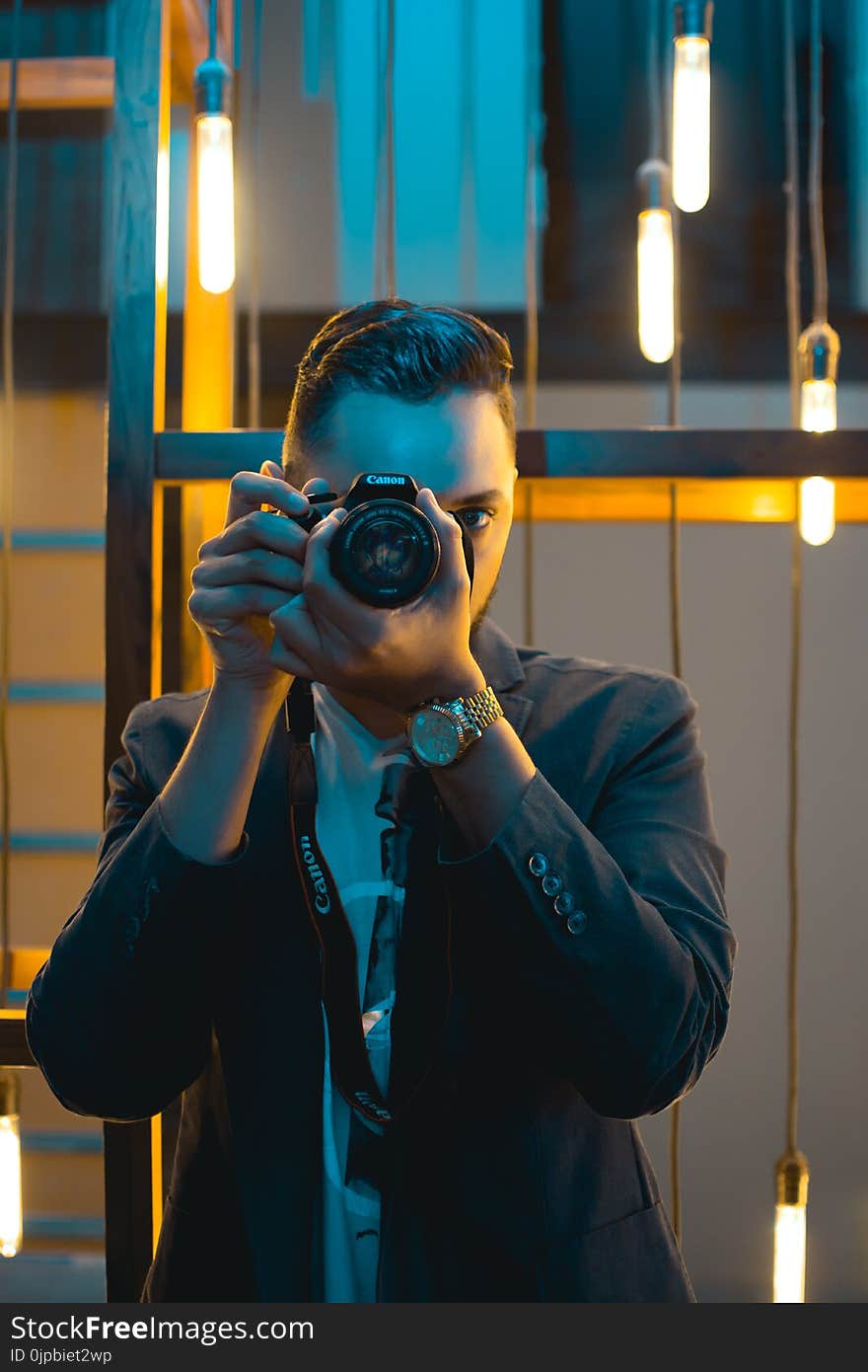 Man in Black Suit Holding Canon Dslr Camera