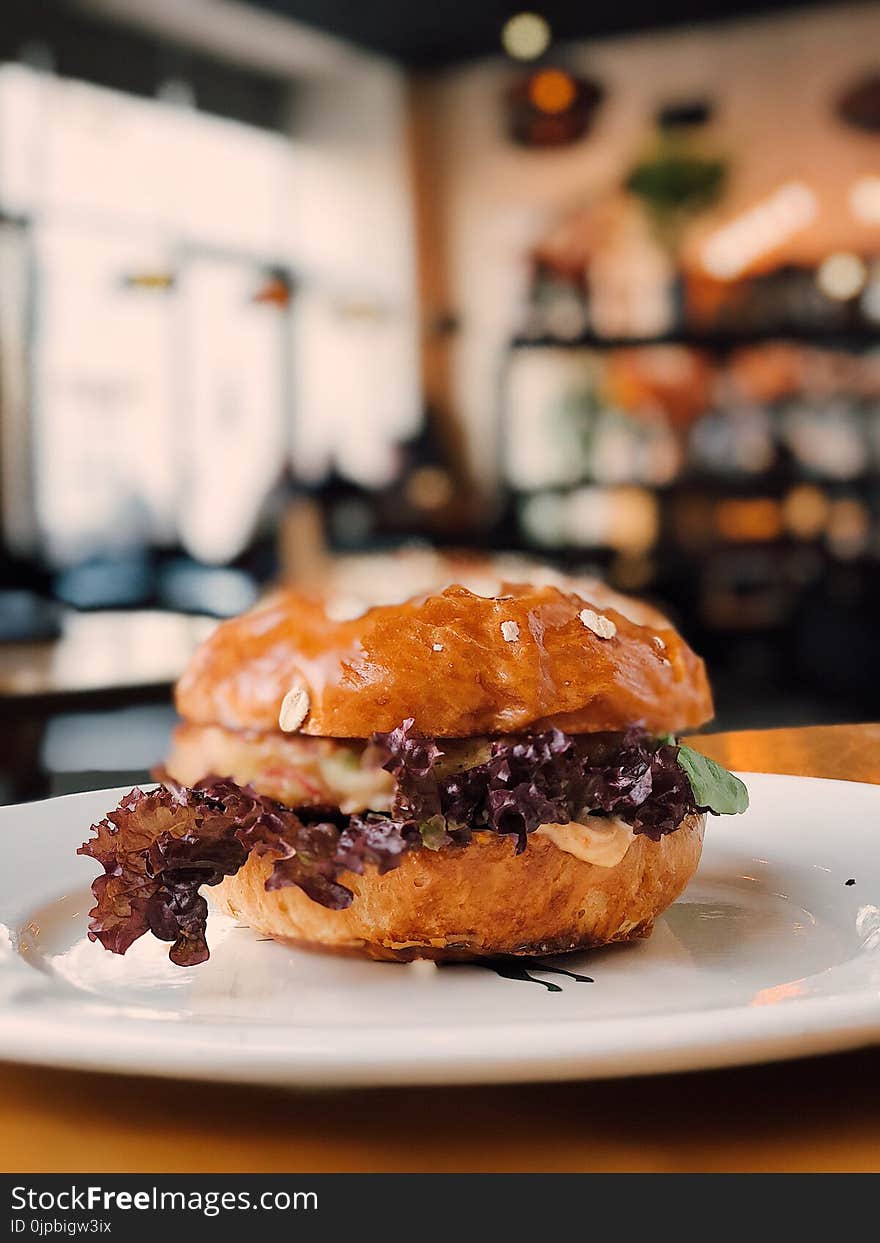 Selective Focus Photography of Burger on White Ceramic Plate