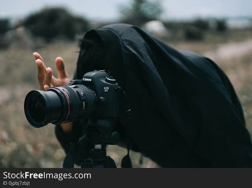 Person in Black Jacket Facing Black Canon Dslr Camera