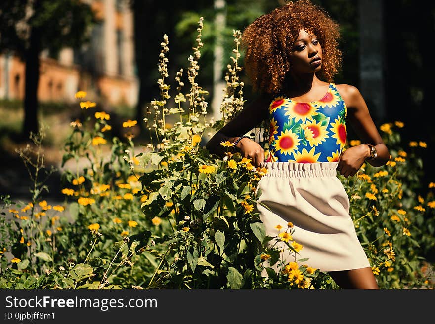 Photography of Woman Wearing Blue, Yellow and Red Floral Tank Top Standing