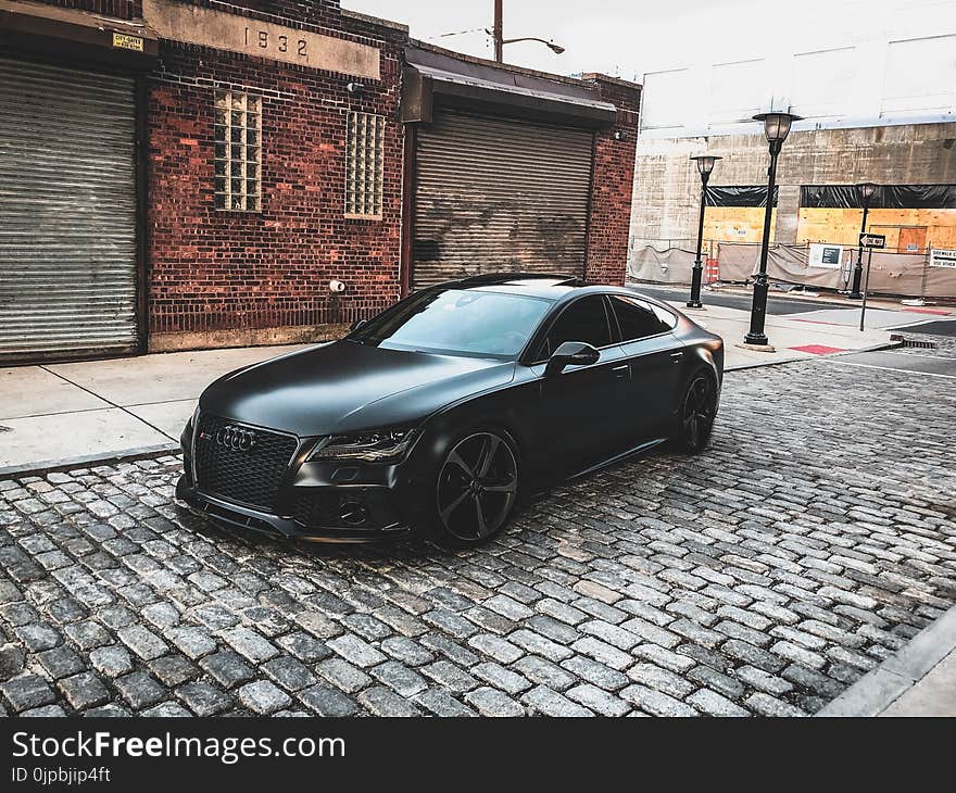 Black Audi A-series Parked Near Brown Brick House