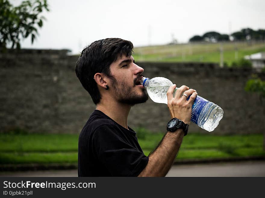 Man Wearing Black Shirt Drinking Water