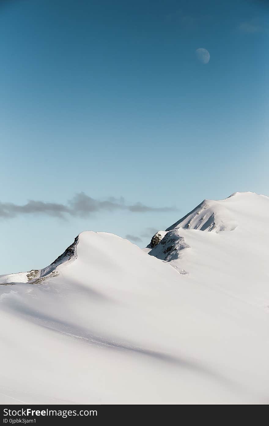 Photo of Mountain Range Covered With Snow Under Moon