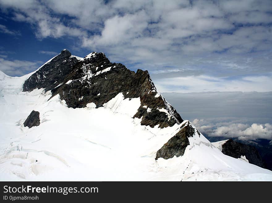 Snow Capped Mountain Under Cloudy Sky