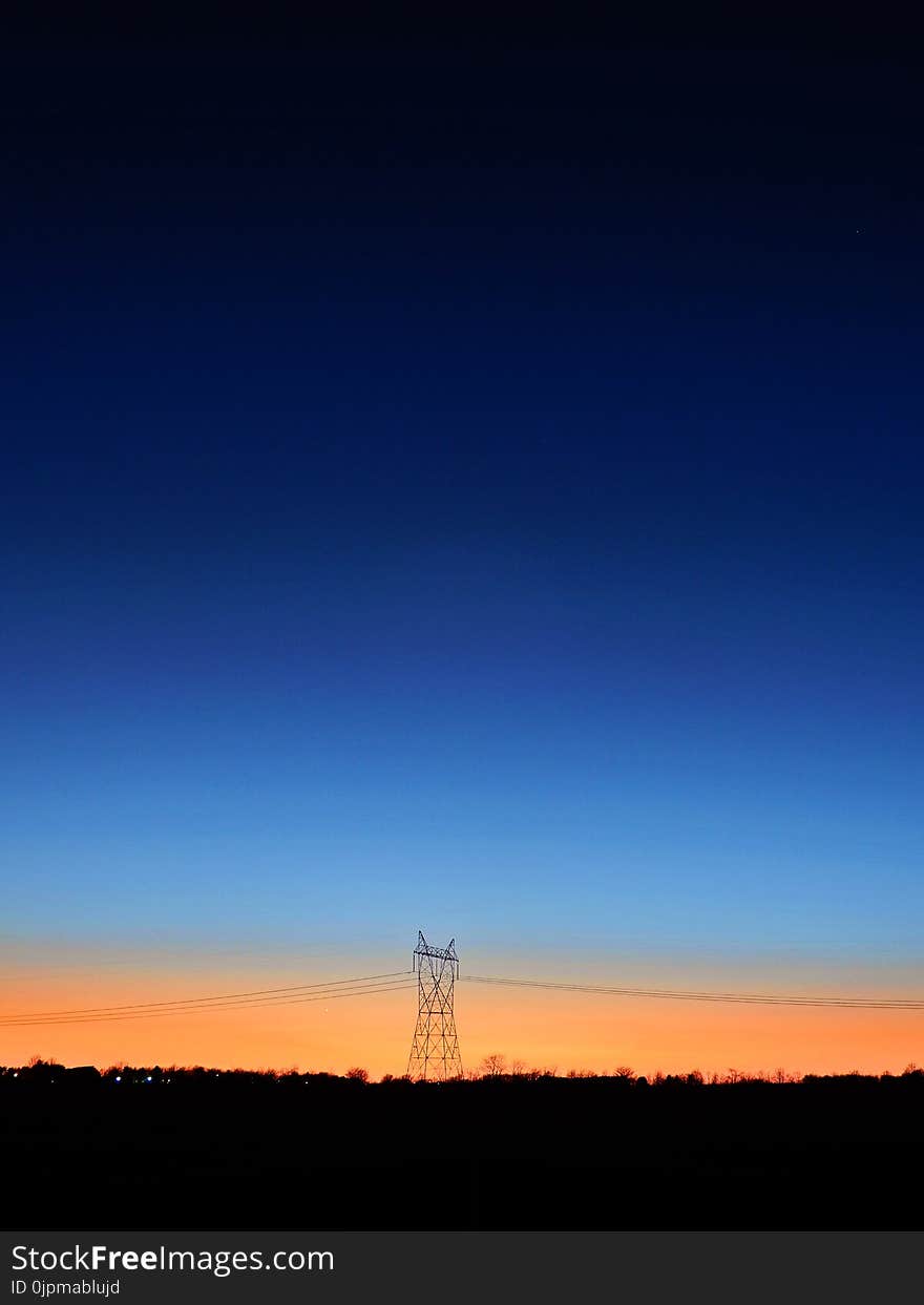 Black Transmitter Tower Under Blue and Orange Sky