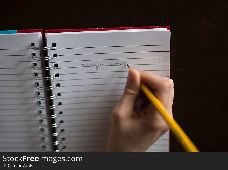 Person Writing on White Lined Paper